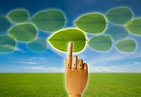 Saved green with touch screen, wooden hand pressing leaf buttonの写真素材