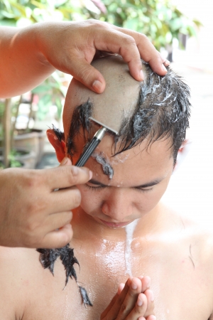BANGKOK, THAILAND - MAY 25 : Thai youth man during the ceremony shaved to a priest of Buddhist monk on May 25, 2013 in Bangkok, Thailand, Thai men at the age of 20 years will become Buddhist monk.のeditorial素材