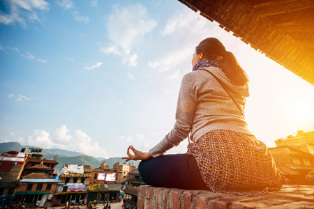 Silhouette hipster girl doing yoga at sunset ancient city in Nepal.の写真素材