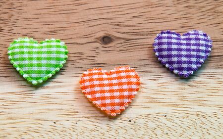 Heart made of cloth on a wooden floor.の写真素材