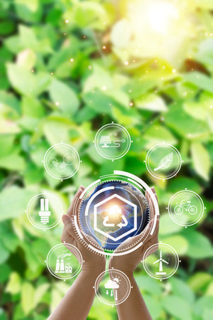 Smart industry 4.0 concept, Hand holding smart factory and light bulb on nature backgroundの写真素材