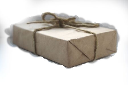 gift box wrapped in paper and wrapped with rope on a white background clouded sky