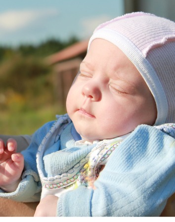 Happy mother with baby having fun outdoors, joyful young mom lifting up her precious sweet kid, enjoying parenthoodの写真素材