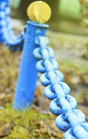 A large old blue chain of rusty metal in the city.
