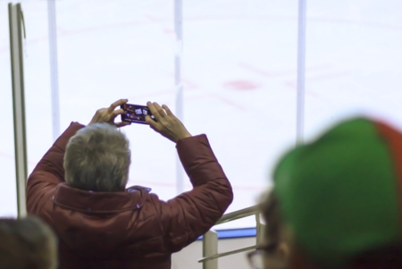 people, friendship, sport and leisure - happy friends watching the game. person takes a hockey match by phone, stopの写真素材