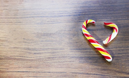 candy in the shape of heart on a wooden background for the celebration of Valentine's Day. Heart is broken. Cheating.の写真素材