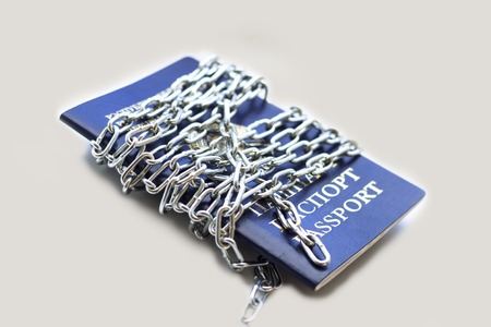 Blue passport wrapped in a chain. Background light gray. No insulationの写真素材
