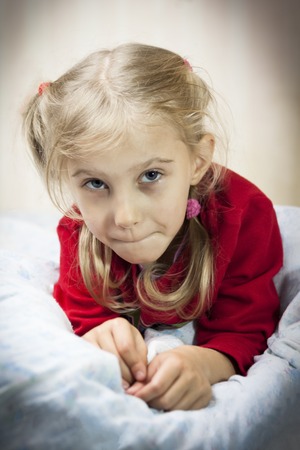 young girl with white hair lies on the bed. there is vignetting. close-up.