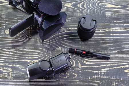 video camera, lens, flash, on a dark wooden background in vintage style.の写真素材