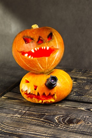 Halloween, two pieces or one, in the eye is a lantern camera with burning candles on a black background. Halloween celebration, celebration.の写真素材