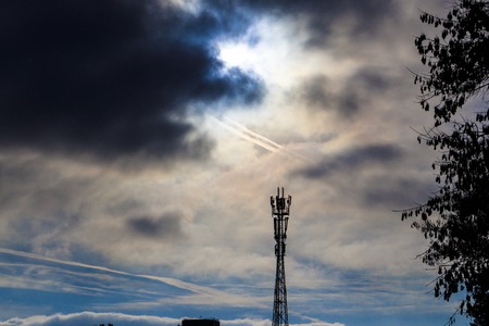 black sky. Telecommunication tower against a stormy cloudy sky.