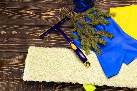 dark wooden background, mop and gloves. there is a scraper for glasses and cleaning products. there is tanirovanieの写真素材