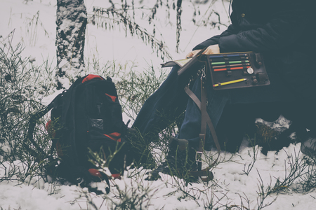 it is cold in winter, it is snowing. Girl with a compass map and odometer in hand, paves the route. there is toning.の写真素材