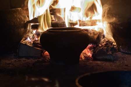 Russian stove. there is a cast-iron pot and a frying pan with egg and meat. on an open fire. there is toningの写真素材