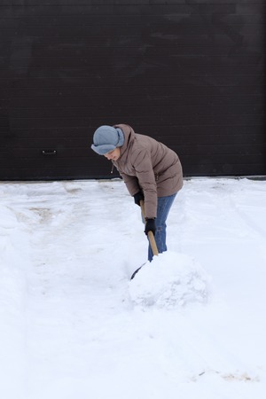 Winter is a lot of snow. A young girl, cleans, proud of doing the big shovel work.の写真素材