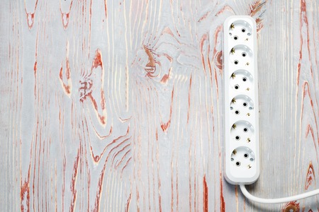 wooden background in retro style, on it is an extension cord with European cutsの写真素材
