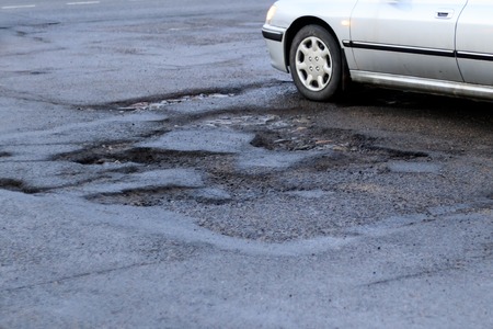 roadway. it has a lot of holes that need repair. have a car. toningの写真素材
