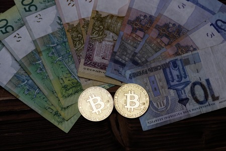 cryptocurrency, bitcoins, paper of the Belarusian ruble. Metal coins are laid out on a flat background, close-up from above, cryptocurrency money exchangeの写真素材