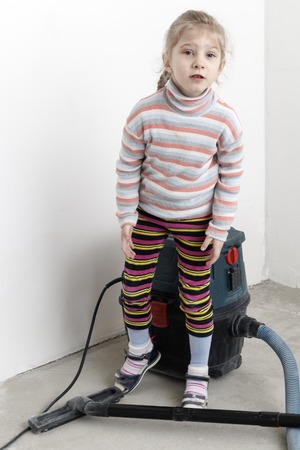 girl with white hair. removes the house after a major overhaul. in the hands of the dust collectorの写真素材