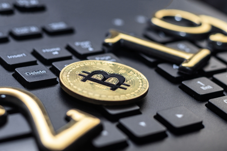golden bitcoin It lies on the keyboard of a dark color. The inscription 2019. There is a toning.