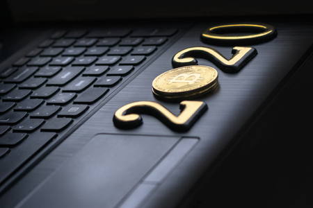 golden bitcoin It lies on the keyboard of a dark color. The inscription 2020. There is a toning.の写真素材
