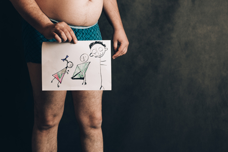man in shorts against the background of the school board. in the hands of children's drawingの写真素材