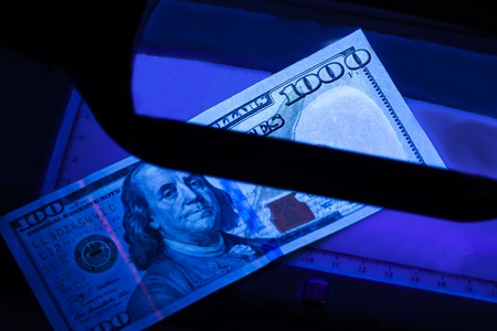 thousand dollars in the photo. US banknotes. Equipment for in-depth inspection of money. Checking...