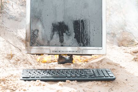 beach sand. bright sun. the monitor burns with smoke. have a keyboardの写真素材