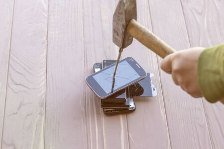 daylight. hammer hit on the phones. in one of them there is a metal nail.の写真素材