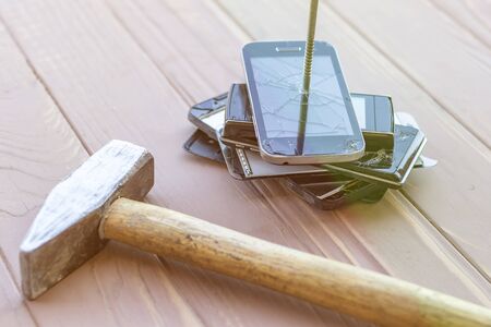 daylight. hammer hit on the phones. in one of them there is a metal nail.の写真素材