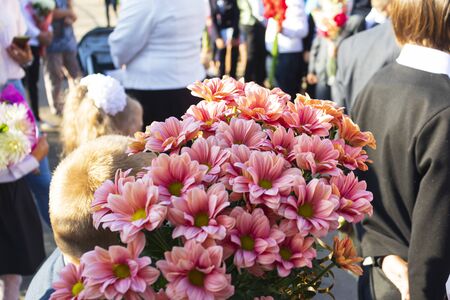 blonde girl holding flowers in her hands. the beginning of the school year. first callの写真素材