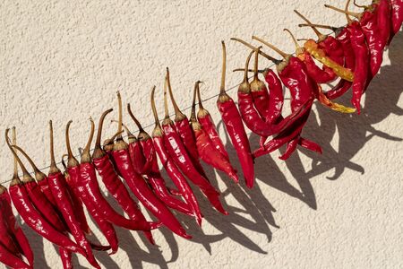 daylight. red pepper dries on a rope in the street. there is tintingの写真素材