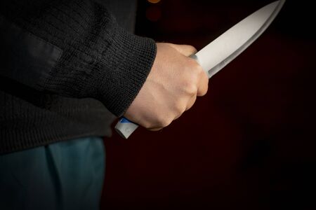 full night. a man holding a knife. close-up. concept of violence