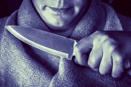 full night A man holds a knife at the girl's throat. close-up. concept of violence