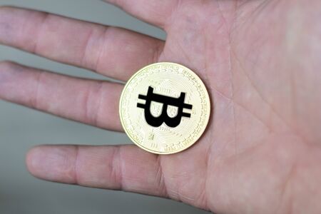 man holding a bitcoin coin in his hand. schedule close-up