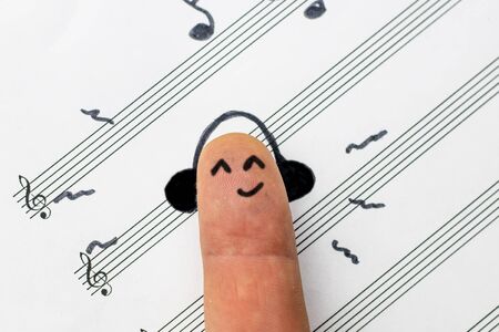 concept. finger lies on notes and listens to music. he is satisfiedの写真素材