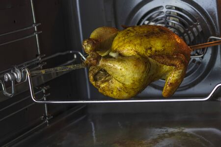 oven. grilled chicken is cooked on a spit. it gradually rotates on the vertical.の写真素材