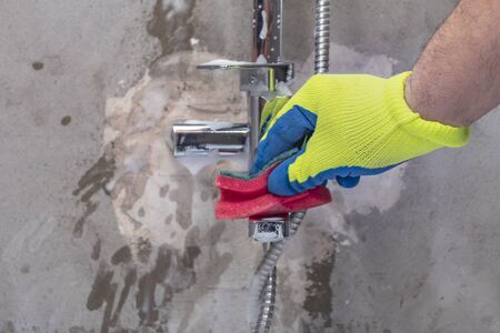 close-up. the master clamps the nut. fasten the tap to the wallの写真素材