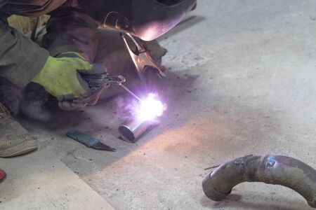Close-up. Worker weld stainless steel metal products. Establishes a seam.