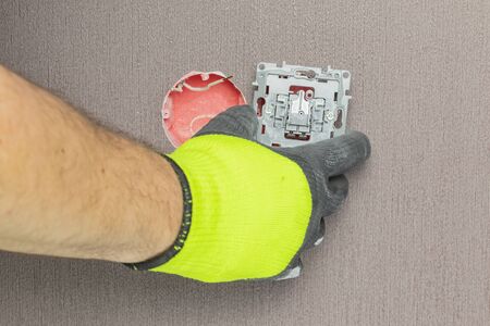 the master electrician sets the switch. Close-up. The room is colored. The switch is brown. The keys...