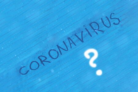 blue, foggy glass, the inscription coronavirus on it. Close-up