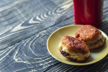 dark wooden background on it is a texture. A cup of black coffee and 2 donuts from homemade pastries with a filling inside.の写真素材