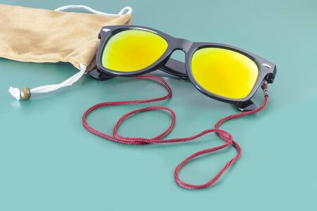 Wooden background in green style on it lie sunglasses and a fabric cover next to it. Close-up. There is a tint.の写真素材