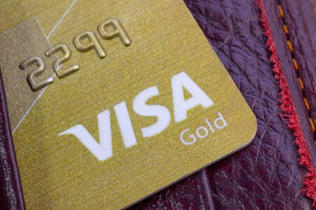 Minsk. Belarus. January 30, 2020. Wood background Bank card Close-up Gold visaのeditorial素材