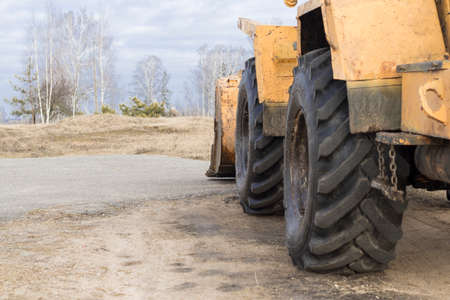 Daylight Yellow loader with a bucket. There is a tint. Close-up.