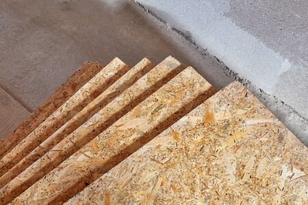 OSB slab building material made from reborn sawdust. They are stacked. Close-up.