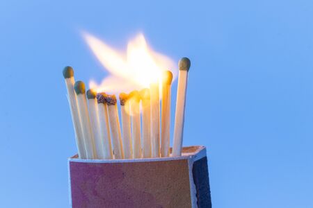 box of matches. A few pieces were stuck in a box and set on fire. Close-up. Blue backgroundの写真素材