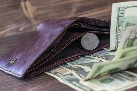 Cinnamon wallet. It has five rubles and next to it are banknotes of one hundred dollars. Foreign currency growth concept.の写真素材