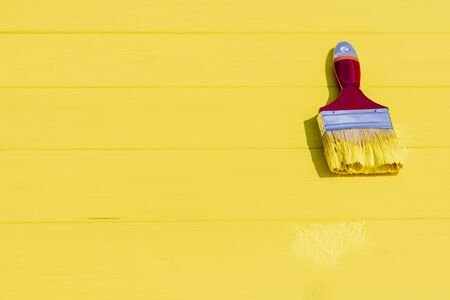 bright lighting. A hard shadow falls on the brush. Yellow wooden background in retro style. Copy space.の写真素材