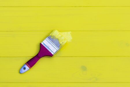 even lighting. Paint brush in yellow. retro style wooden background. Copy space.の写真素材